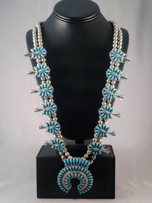 Shiprock Trading Post - This traditional squash blossom necklace has such a  rich history and meaningful symbolism behind it. We love working with  artists that honor their culture through their beautiful jewelry! |